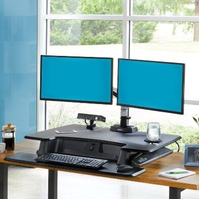 Computer desk with two monitors and various accessories on it